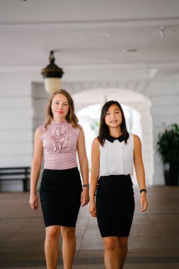İki iş (bir Çinli Asyalı kadın ve beyaz bir kadın) farklı bir takım portresi. Rahat bir şekilde gülümsüyor musun.