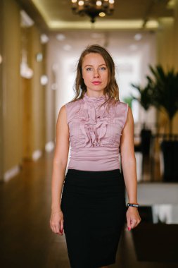 bir genç, uzun boylu, çekici sarışın beyaz bir kadın portresi. O profesyonel ofis kıyafet ve poz giyinmiş 