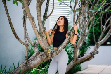 Çekici, genç Çinli Asyalı bir kadın portresi sportif, aktif giyim yeşil Parkı Singapur hafta sonu gün içinde giyinmiş.