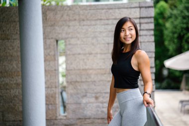 Çekici, genç Çinli Asyalı bir kadın portresi sportif, aktif giyim yeşil Parkı Singapur hafta sonu gün içinde giyinmiş.