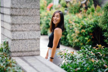 Çekici, genç Çinli Asyalı bir kadın portresi sportif, aktif giyim yeşil Parkı Singapur hafta sonu gün içinde giyinmiş.