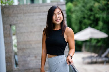 Çekici, genç Çinli Asyalı bir kadın portresi sportif, aktif giyim yeşil Parkı Singapur hafta sonu gün içinde giyinmiş.