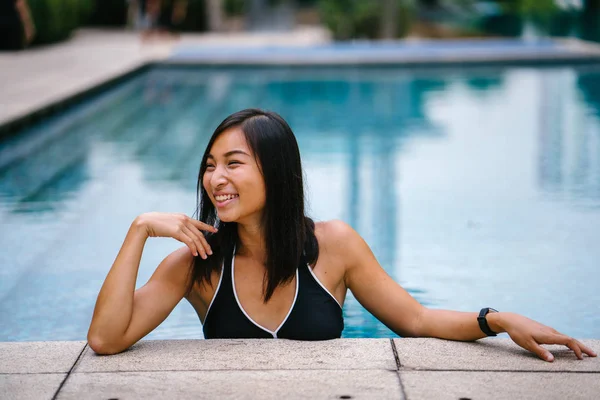 그녀의 수영복에 수영장의 가장자리를 기대어 아시아 여자의 초상화 그녀는 그녀는 — 스톡 사진