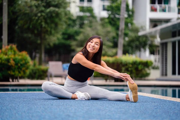 Hafta sonu gün içinde Havuzu yakınındaki egzersizleri yapıyor sportif, aktif giyim çekici, Genç Çinli Asyalı bir kadın portresi giymiş.