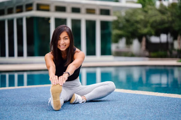 Hafta sonu gün içinde Havuzu yakınındaki egzersizleri yapıyor sportif, aktif giyim çekici, Genç Çinli Asyalı bir kadın portresi giymiş.