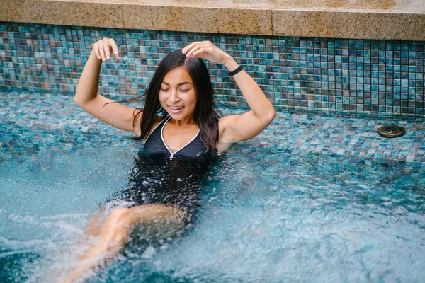 그녀의 수영복에 수영장에서 아시아 여자의 초상화 그녀는 미소와 편안한 — 스톡 사진