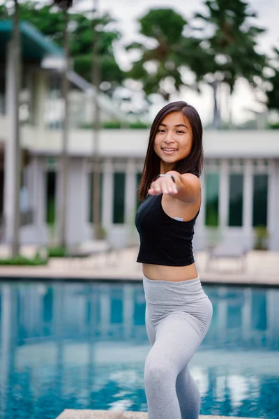 Hafta sonu gün içinde Havuzu yakınındaki yoga yaparken sportif, aktif giyim çekici, Genç Çinli Asyalı bir kadın portresi giymiş.