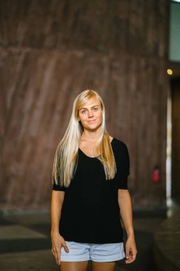 Asya kentsel onun kampüs içinde gündüz yürüyen bir genç ve atletik sarışın kadın portresi. O rahat, sportif ve rahat kıyafetleri giymiş ve spor ayakkabıları ve o yürürken gülümsüyor