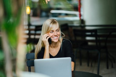 Onun önünde onu dizüstü bilgisayar ile telefonunda bahseden bir genç, çekici ve fotojenik sarışın kadın portresi. O onun çağrı alır gibi o gün boyunca bir kafede oturduğundan.