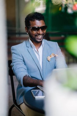 3 adet elbiseli Hintli Asya adam yakışıklı ve çapkın onun dizüstü bilgisayarda çalışıyor. O gün boyunca bir masada oturmuş ve sakin görünüyor