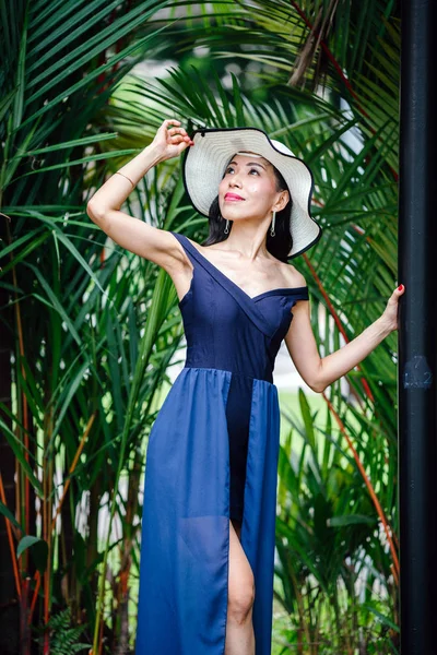 아시아에서 공원에서 모자와 포즈는 우아한 파란색 드레스에 아시아 여자의 초상화 — 스톡 사진