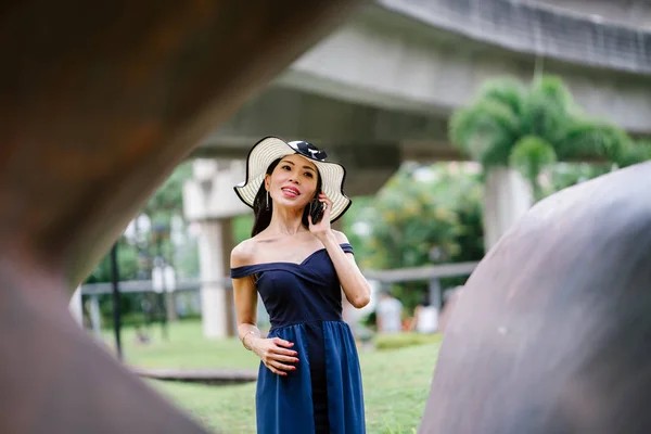 드레스와 스마트폰으로 공원에 모자에 아시아 여자의 초상화 — 스톡 사진