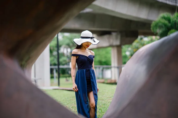 アジアの公園で日中は白いつばの広い帽子でポーズ エレガントな青いドレスのアジア中国の女性の肖像画 — ストック写真