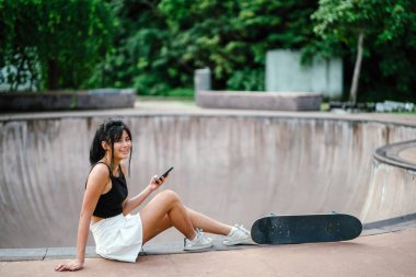 Cep telefonu ve paten skatepark Asyalı Çinli Kız portresi