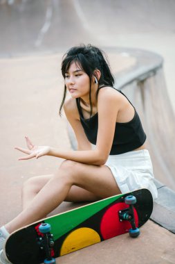 Cep telefonu ve paten skatepark Asyalı Çinli Kız portresi