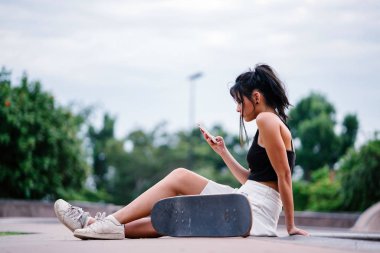 Cep telefonu ve paten skatepark Asyalı Çinli Kız portresi