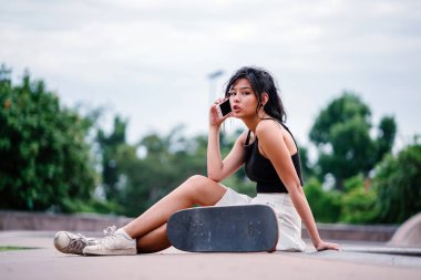 Cep telefonu ve paten skatepark Asyalı Çinli Kız portresi