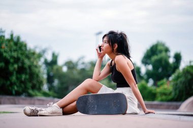 Cep telefonu ve paten skatepark Asyalı Çinli Kız portresi