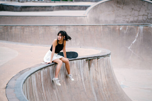 Portrait of Asian Chinese girl with skate in skatepark