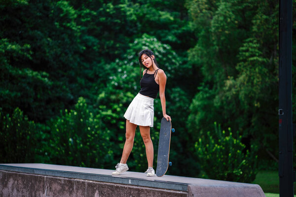 Portrait of Asian Chinese girl with skate in skatepark