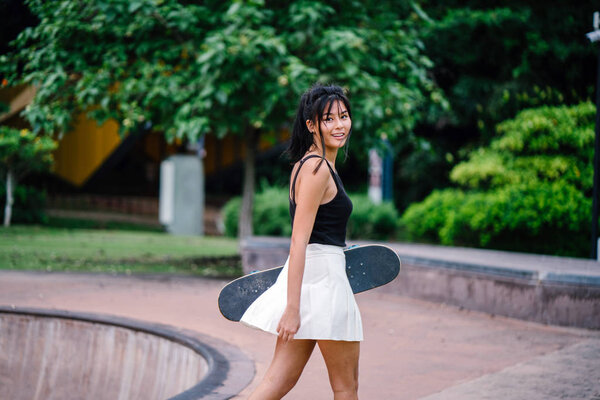 Portrait of Asian Chinese girl with skate in skatepark