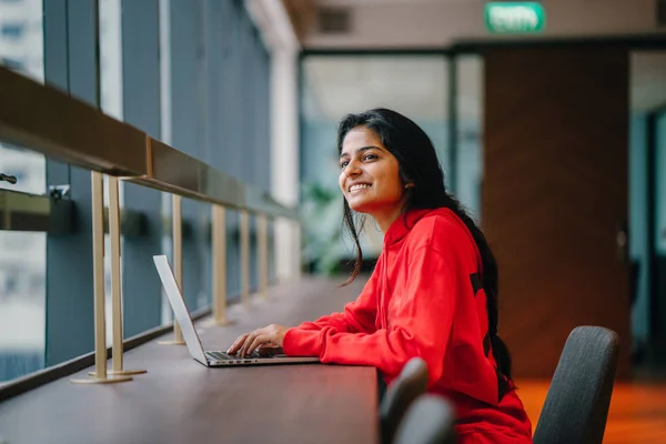 Bella Ragazza Sorridente Digitando Sul Computer Portatile Seduto Tavola — Foto Stock