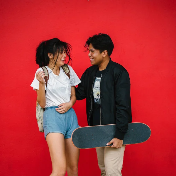 Felice Giovane Coppia Divertirsi Piedi Sfondo Rosso Con Skateboard — Foto Stock