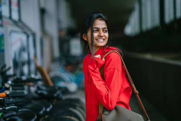 Smiling Indian Girl Bag Standing Dark Background Parked Bikes — Stock Photo, Image