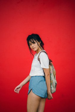 Kırmızı studio arka planda, üç çeyrek boy poz güzel Asyalı kız