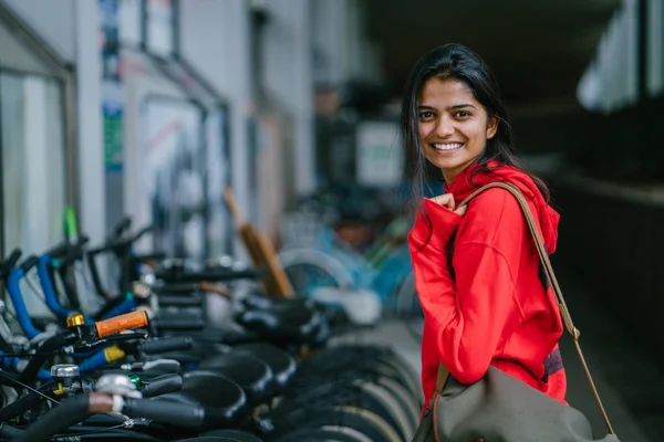 駐車しているバイクを背景に立っている笑顔のインドの少女の肖像画 — ストック写真