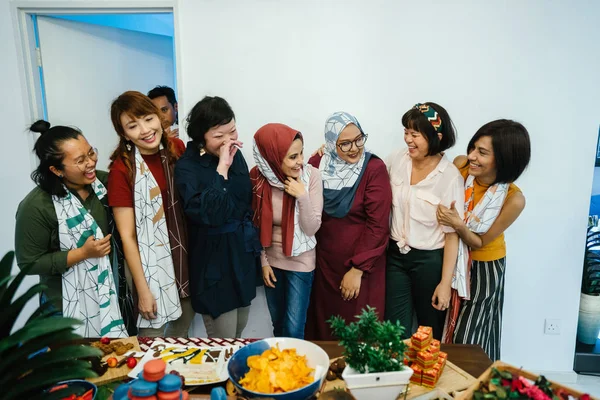 asian women standing near table with snacks and sweets celebrating holiday