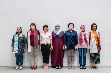 Grup Asyalı kadını ayakta beyaz duvar arka planda, tam uzunlukta poz