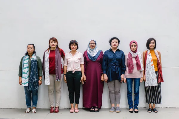 group of asian women posing standing on white wall background, full length