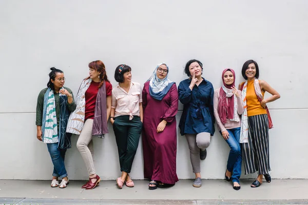 group of asian women posing standing on white wall background, full length