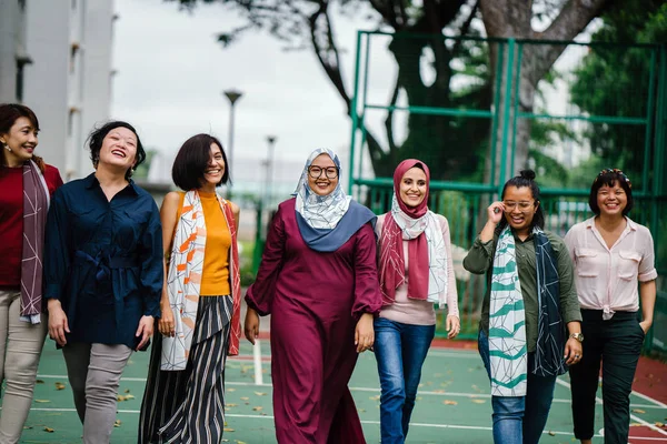 diverse group of asian women walking together on basketball court