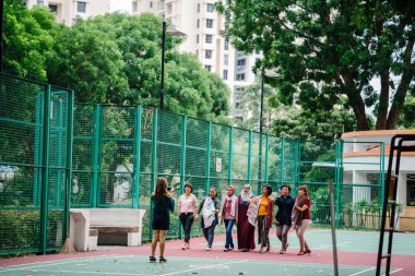 Asyalı kadınlar basketbol sahasına, tam uzunlukta birlikte yürüyüş çeşitli grup