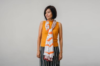 Stüdyo portre rahat kıyafetler giymiş emin gülümseyen kadın