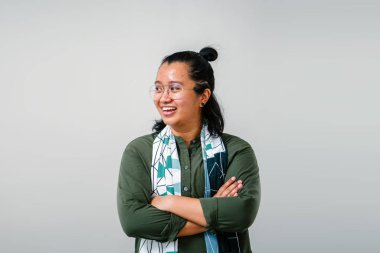 Zeytin Yeşil gömlek, gözlük ve silah ile beyaz stüdyo arka plan üzerinde duran eşarp giyen kadın portresi geçti