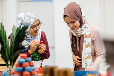 iki kadın ayakta aperatifler tatil kutlamak için hazırlanıyor masada gülümseyen