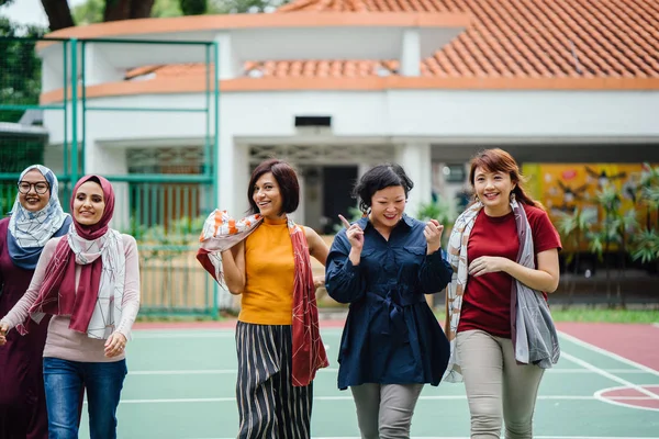 diverse group of asian women walking together on basketball court