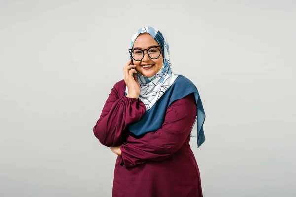 Tudung ヘッド スカーフとスマート フォン 半分の長さのポートレートで話している伝統的な服装を身に着けているアジアの女性 — ストック写真