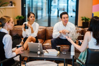 Toplantı salonunun içinde kanepede oturup konuşmayı istirahat iş arkadaşları