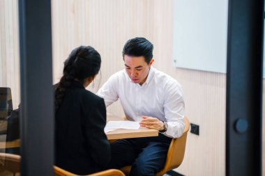 iki iş ortağı, modern ofisinde oturan kağıtlara yazılı belgelerle çalışma 