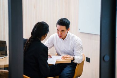 iki iş ortağı, modern ofisinde oturan kağıtlara yazılı belgelerle çalışma 