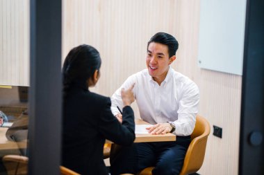 iki iş ortağı, modern ofisinde oturan kağıtlara yazılı belgelerle çalışma 