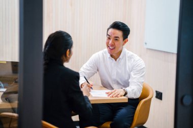 iki iş ortağı, modern ofisinde oturan kağıtlara yazılı belgelerle çalışma 