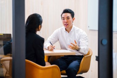 iki iş ortağı, modern ofisinde oturan kağıtlara yazılı belgelerle çalışma 