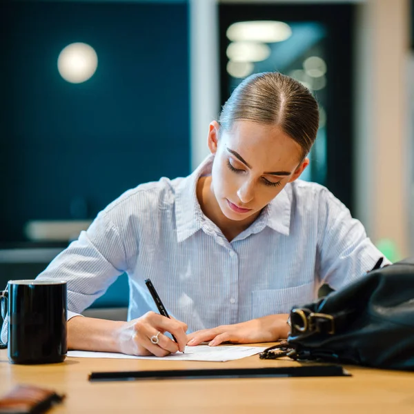 modern ofis masada oturan genç emin iş kadını