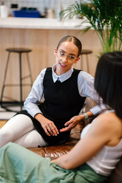 Two Businesswomen Discussing Project Sitting Leather Sofa Modern Office — Stock Photo, Image