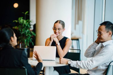 iş adamları modern ofiste dizüstü kullanarak proje tartışıyor 